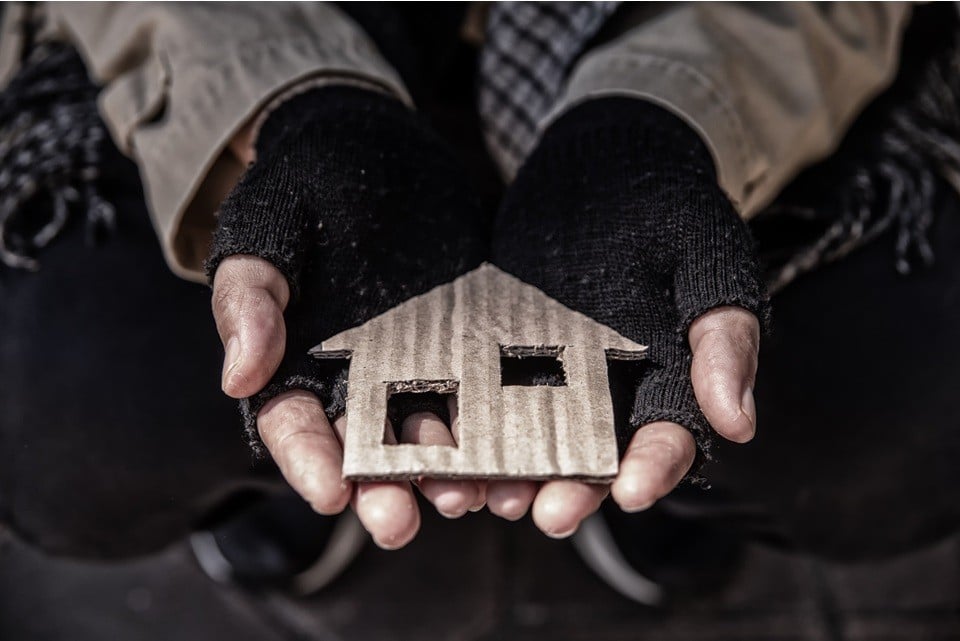A small cardboard house held in two hands