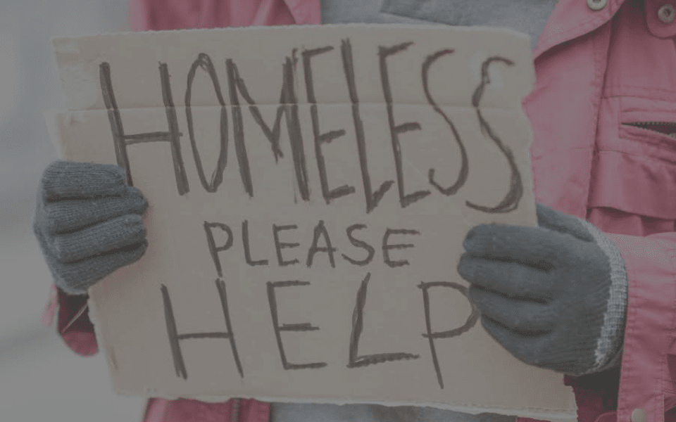 Person holding sign saying 'homeless please help'